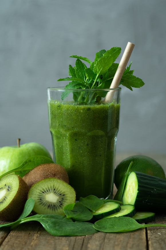 Green smoothie in a glass with leafy garnish